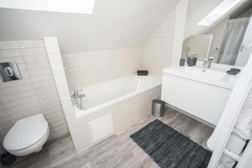 een badkamer met een bad, een toilet en een wastafel bij Salicorne Villa rénovée à l'orée de la zone naturelle in Groffliers