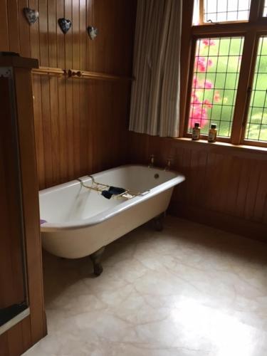 uma banheira branca na casa de banho com uma janela em Hewling's Manor em Geraldine