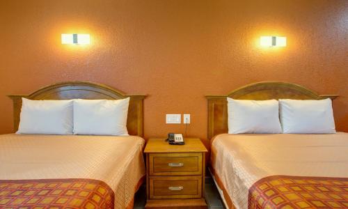 a hotel room with two beds and a night stand at Motel 6 Branson, Mo in Branson