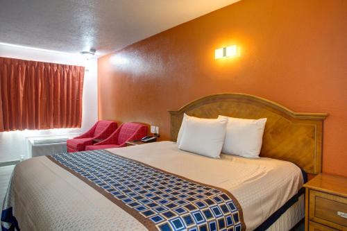 a hotel room with a bed and a red chair at Motel 6 Branson, Mo in Branson