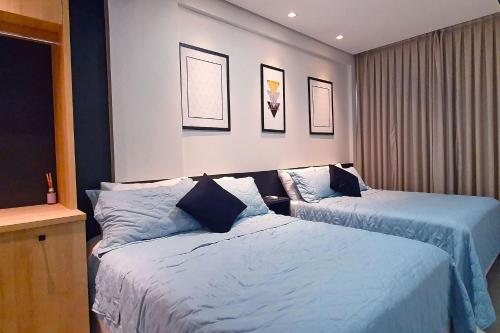 een slaapkamer met 2 bedden met blauwe lakens bij Qavi - Flat completo com piscina privativa #ÎledePipa in Pipa