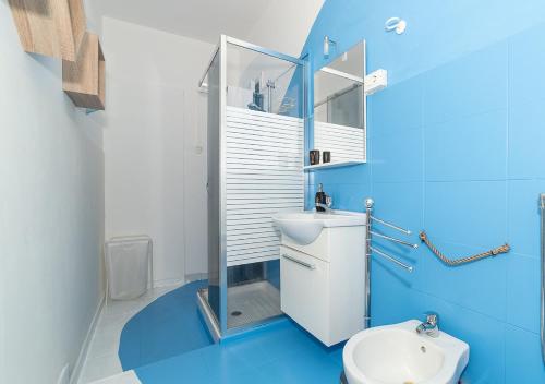 un bagno blu con un water e un lavandino di Bed & Breakfast Firenze a Catania