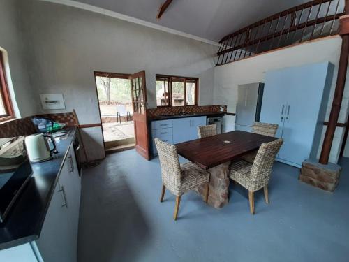 a kitchen with a wooden table and chairs at Rock Cottage, Bela-Bela in Bela-Bela