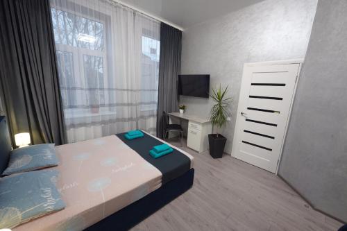 een slaapkamer met een bed, een bureau en een raam bij New cozy apartment near Opera House and “Malevich” in Lviv