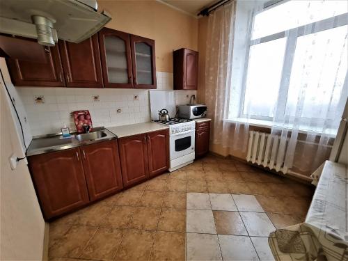 a small kitchen with a sink and a stove at Apartments on Lenina in Mogilev
