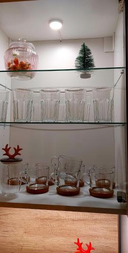 a shelf with glass bowls and plates on it at Brīvdienu māja ar Saunu in Saulkrasti
