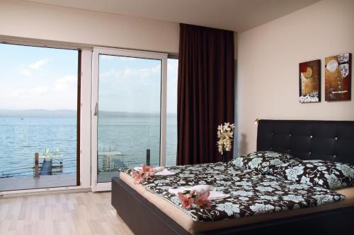a bedroom with a bed with a view of the ocean at Aba Sea House in Balatonszárszó