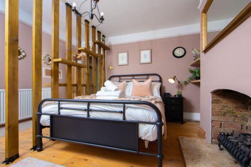 Un dormitorio con una cama y una chimenea. en The Victorian Getaway - Central, en Canterbury