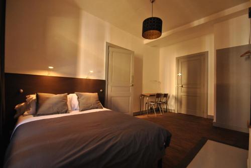 een slaapkamer met een groot bed in een kamer bij Chambres d'hôtes L'Epicurium in Le Puy en Velay