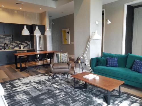 a living room with a green couch and a table at Hotel Rock Lititz in Lititz