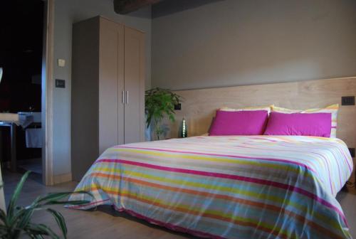 a bedroom with a large bed with pink pillows at b & b Alle 3 palme in San Giórgio di Nogaro