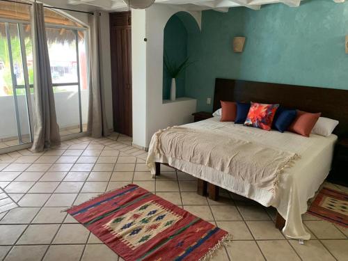 a bedroom with a bed and a blue wall at El Encanto Casa Boutique in Manzanillo