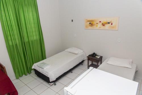 Habitación con 2 camas y cortina verde en Hotel Euzebio´s, en Boa Vista