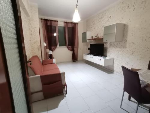 een woonkamer met een rode bank en een televisie bij A casa di Italia in Napels