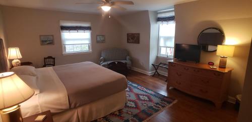 a bedroom with a bed and a flat screen tv at Miller-Dunham House B&B in Middletown