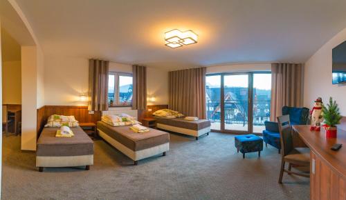 マウェ・チヘにあるU Hankiのベッド2台とリビングルームが備わるホテルルームです。