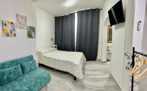 a bedroom with a bed and a couch and a tv at La Marea in Castro di Lecce