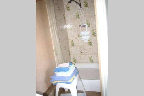a bathroom with a white tub and a stool with towels at Studio dans station de ski aux pieds des pistes in Selonnet