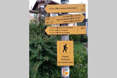 a street sign with many signs on a pole at Studio dans station de ski aux pieds des pistes in Selonnet