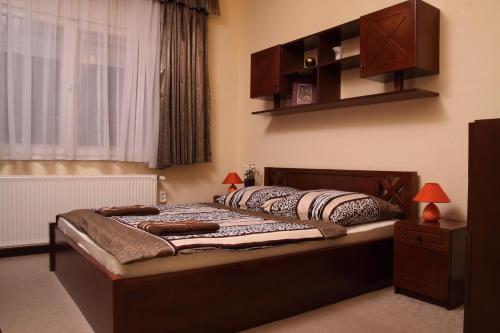 a bedroom with a bed in a room with a window at Aba Wellness House in Balatonszárszó