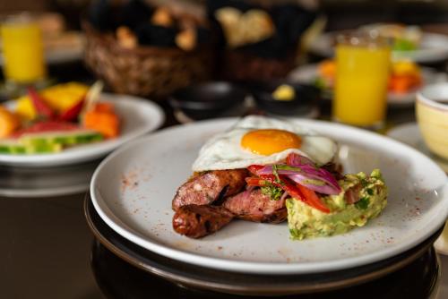 a plate of food with an egg on top at Hotel York Luxury Suites Medellin by Preferred in Medellín