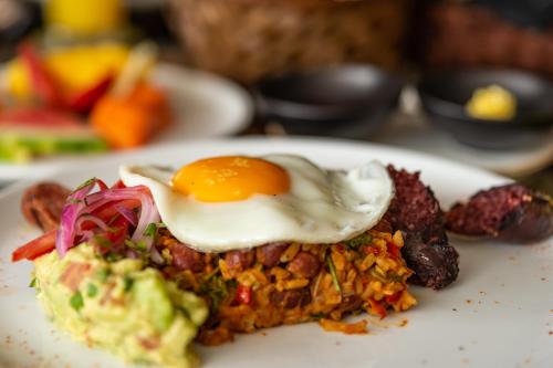 a plate of food with an egg on top at Hotel York Luxury Suites Medellin by Preferred in Medellín