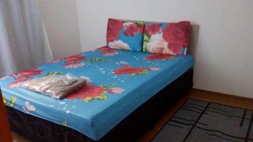 a bed with flowers on it in a room at Apartamento Gaia in Campos dos Goytacazes