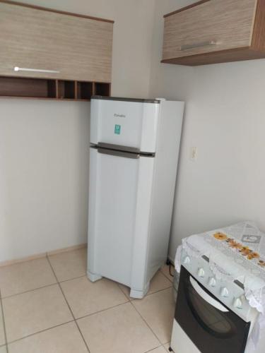 a kitchen with a white refrigerator and a stove at Apartamento Gaia in Campos dos Goytacazes