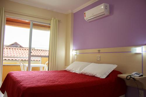 Una cama o camas en una habitación de Bombinhas Praia Apart Hotel - unidade rua Bem Te Vi