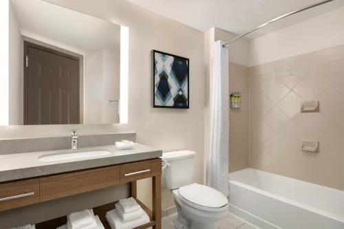 uma casa de banho com um lavatório, um WC e uma banheira em Candlewood Suites Fayetteville Fort Bragg, an IHG Hotel em Fayetteville