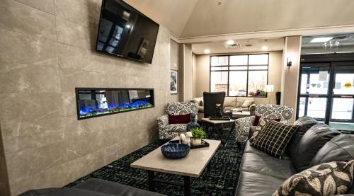 sala de estar con sofá y TV en la pared en Holiday Inn Kearney, an IHG Hotel, en Kearney