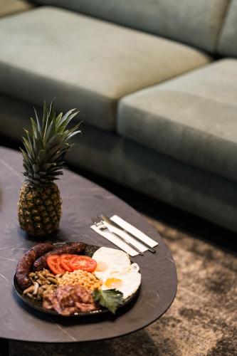 a plate of food on a table with a pineapple at ASKLIPIOS LUXURY SUITE in Tríkala