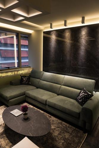 a living room with a couch and a table at ASKLIPIOS LUXURY SUITE in Tríkala
