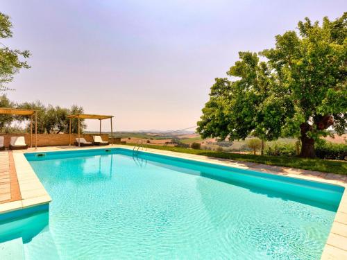 una piscina con agua azul y árboles en Belvilla by OYO Villa Giulia, en Casa Albonetti