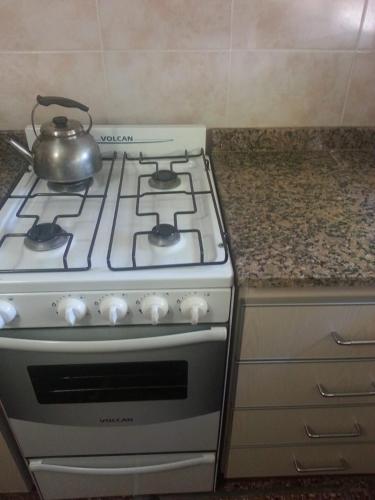 a kitchen stove with a tea kettle on top of it at Departamentos Miramar in Miramar