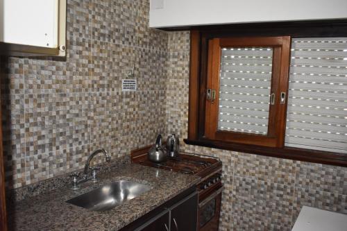 a kitchen with a sink and a window at Departamentos Miramar in Miramar