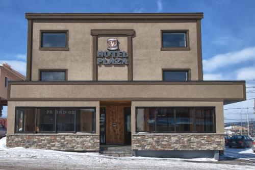 a building with a burger pizza sign on it at Hotel Le Plaza in La Baie