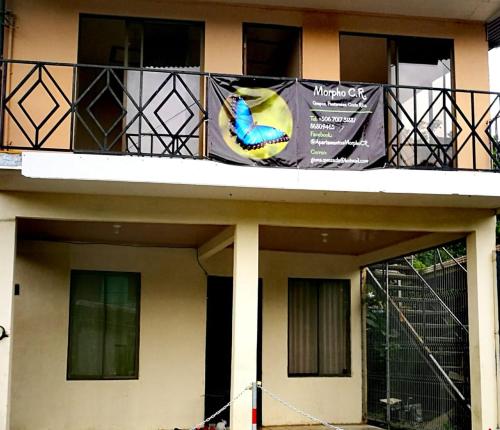 un edificio con un balcón con una pancarta. en Apartamento Equipado Morpho CR., en Quepos