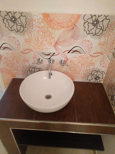 a bathroom with a white sink on a wooden counter at Departamentos Miramar in Miramar