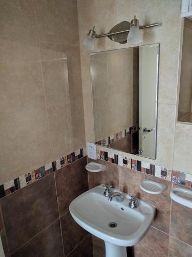 a bathroom with a sink and a mirror at Departamentos Miramar in Miramar