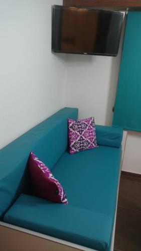 a blue couch with two pillows on top of it at Departamentos Miramar in Miramar