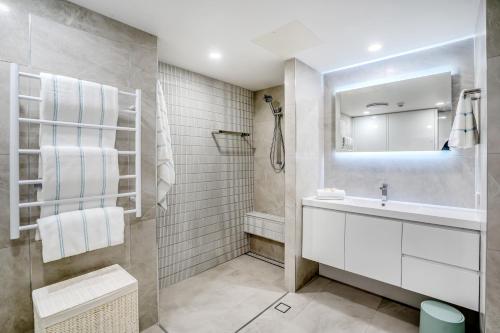 a white bathroom with a sink and a mirror at Pacific Plaza Apartments in Gold Coast