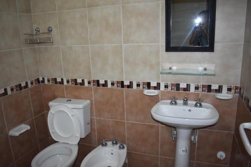 a bathroom with a toilet and a sink at Departamentos Miramar in Miramar