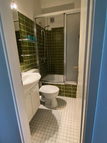 La salle de bains est pourvue de toilettes, d'un lavabo et d'une douche. dans l'établissement Urlaub am Strand, à Timmendorfer Strand