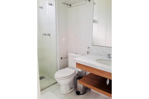 a bathroom with a toilet and a sink and a mirror at Flat TOP e PERFEITO inteiro na Barra da Tijuca com cozinha, lavanderia, GARAGEM e wi fi in Rio de Janeiro