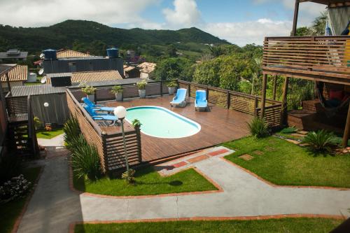 Un patio trasero con piscina y terraza. en LAS ROZAS Parador, en Praia do Rosa