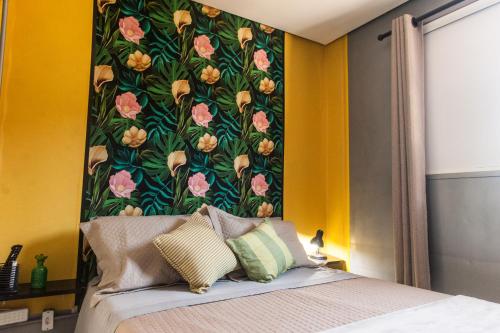 1 dormitorio con pared y papel pintado con flores en LAS ROZAS Parador, en Praia do Rosa