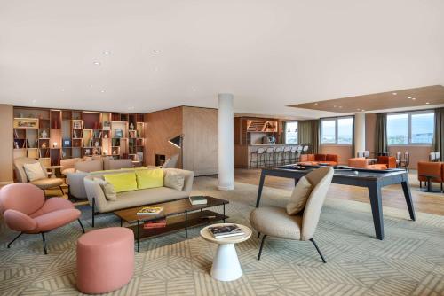 a living room with furniture and a table at Hyatt House Paris Charles de Gaulle Airport in Roissy-en-France