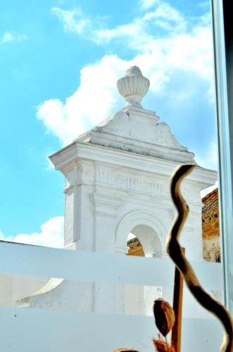 a view of a white building through a window at Hostal Campito in Conil de la Frontera