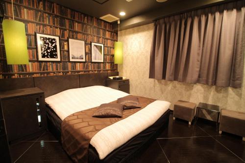 a bedroom with a large bed with two pillows on it at Hotel K Omiya (Adult Only) in Saitama